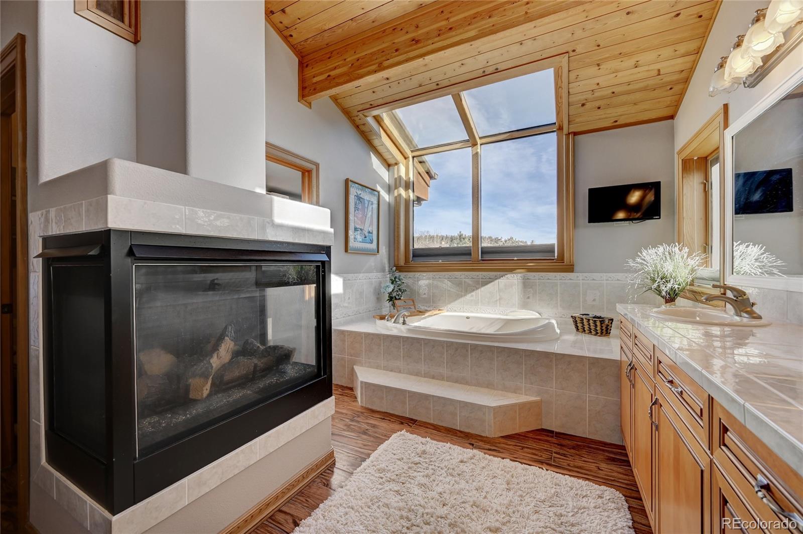 27164 Sun Ridge Drive Evergreen, CO 80439 - Photo 22 of 40 a view of a kitchen with a sink and a fireplace