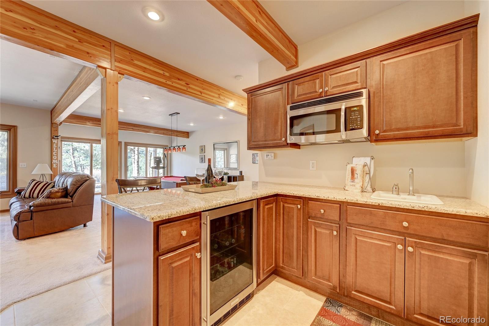 27164 Sun Ridge Drive Evergreen, CO 80439 - Photo 31 of 40 a kitchen with stainless steel appliances granite countertop a sink and cabinets