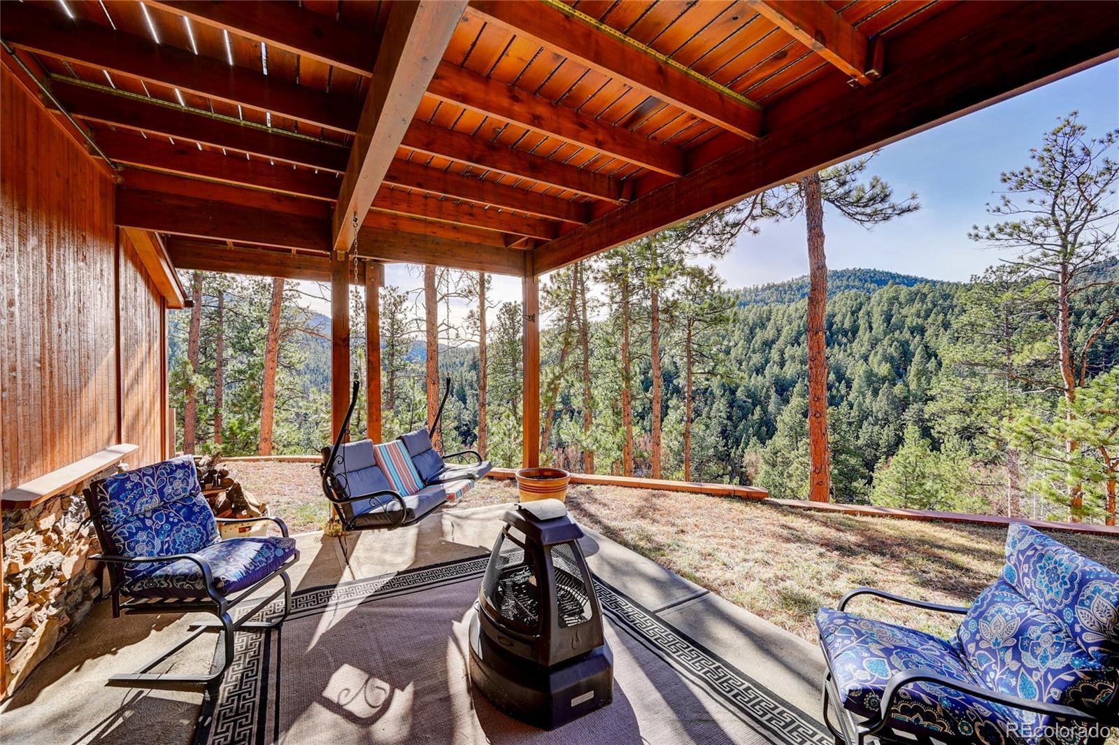 27164 Sun Ridge Drive Evergreen, CO 80439 - Photo 36 of 40 a view of a patio with table and chairs and potted plants
