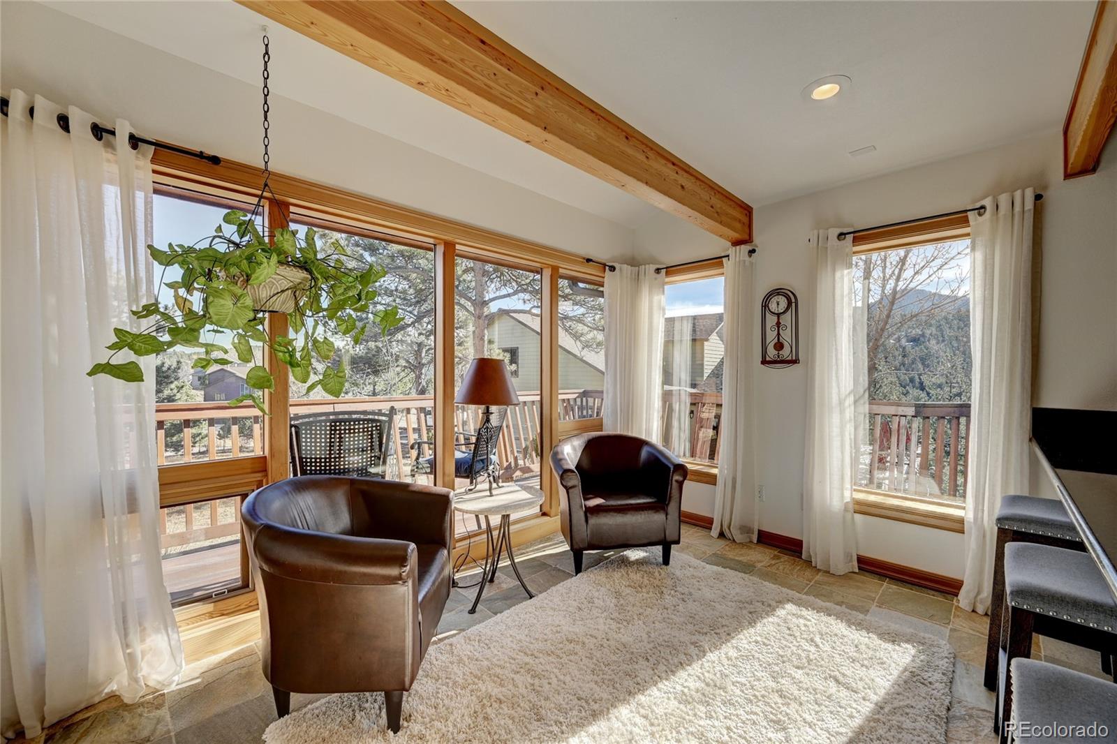 27164 Sun Ridge Drive Evergreen, CO 80439 - Photo 5 of 40 a living room with furniture a rug and a window