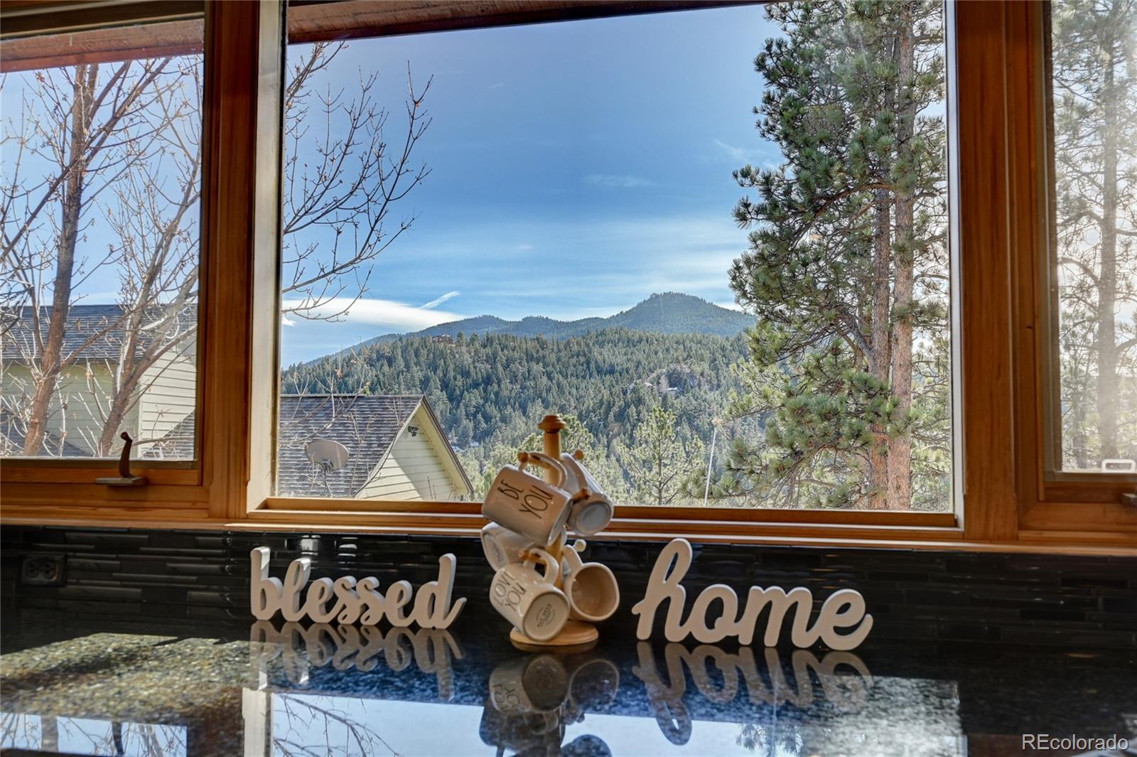 27164 Sun Ridge Drive Evergreen, CO 80439 - Photo 8 of 40 a view of a two chairs and table in patio