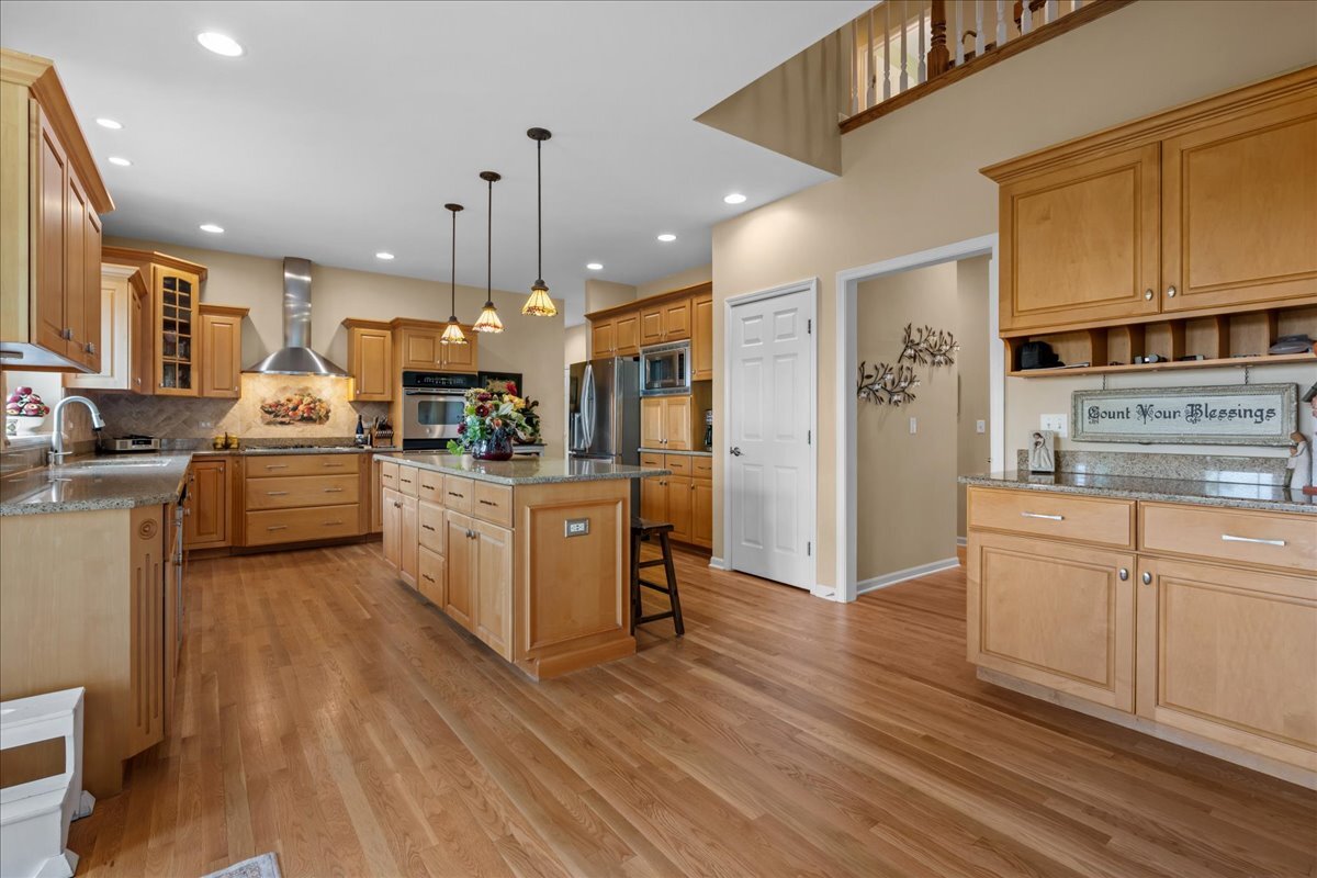 430 Alberosky Way Batavia, IL 60510 - Photo 14 of 49 a kitchen with stainless steel appliances kitchen island granite countertop a refrigerator a oven a stove and white cabinets with wooden floor