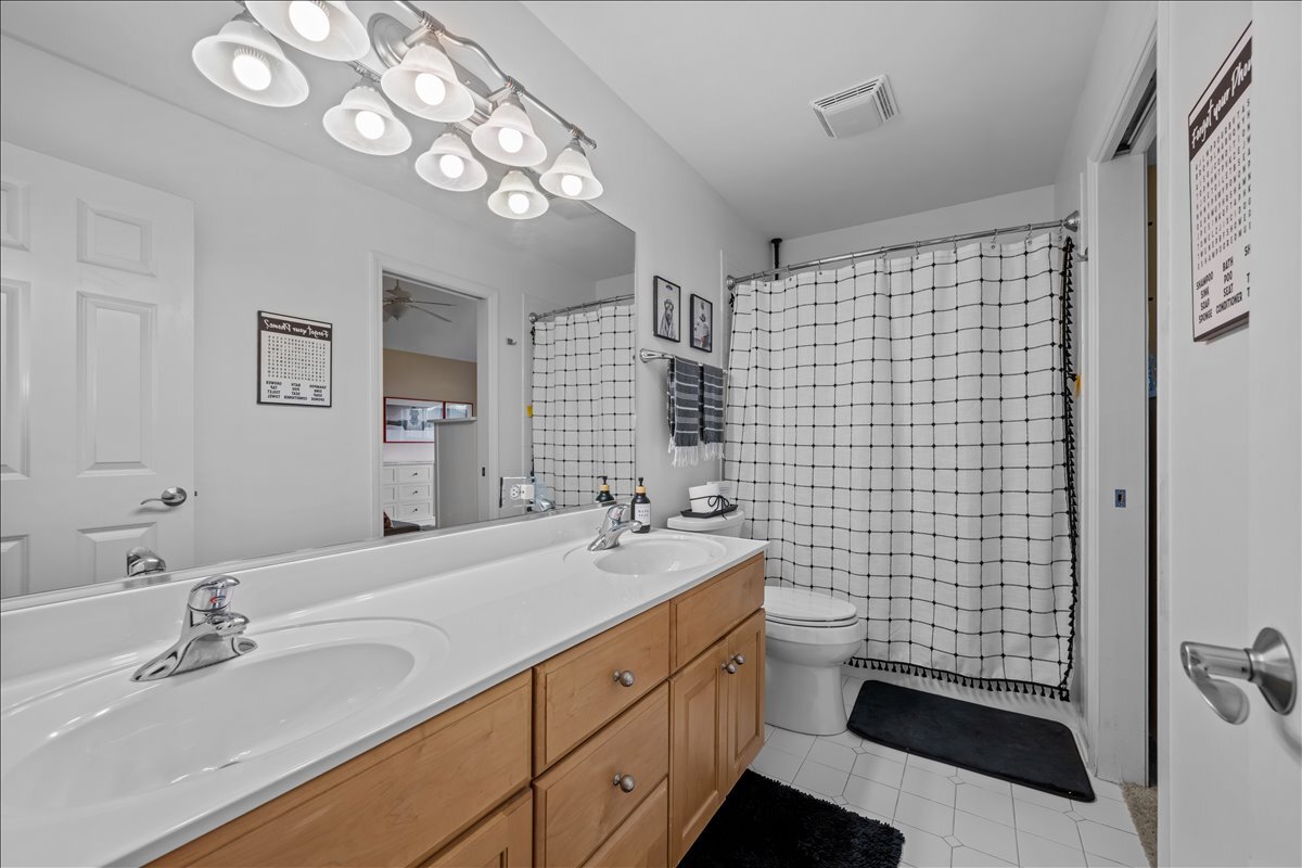 430 Alberosky Way Batavia, IL 60510 - Photo 27 of 49 a bathroom with a sink a toilet a mirror and shower curtain