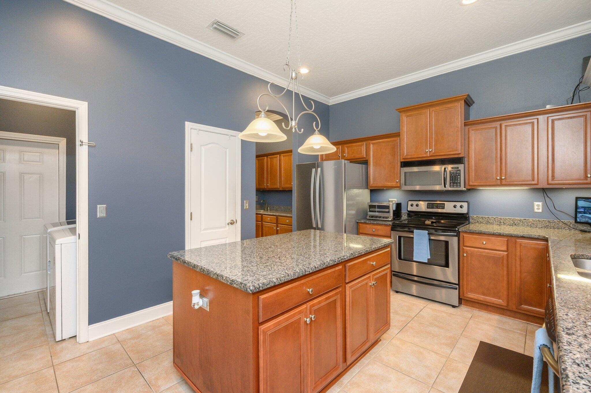 203 Eleases Crossing Crestview, FL 32539 - Photo 11 of 43 a kitchen with stainless steel appliances granite countertop a stove a sink and a refrigerator