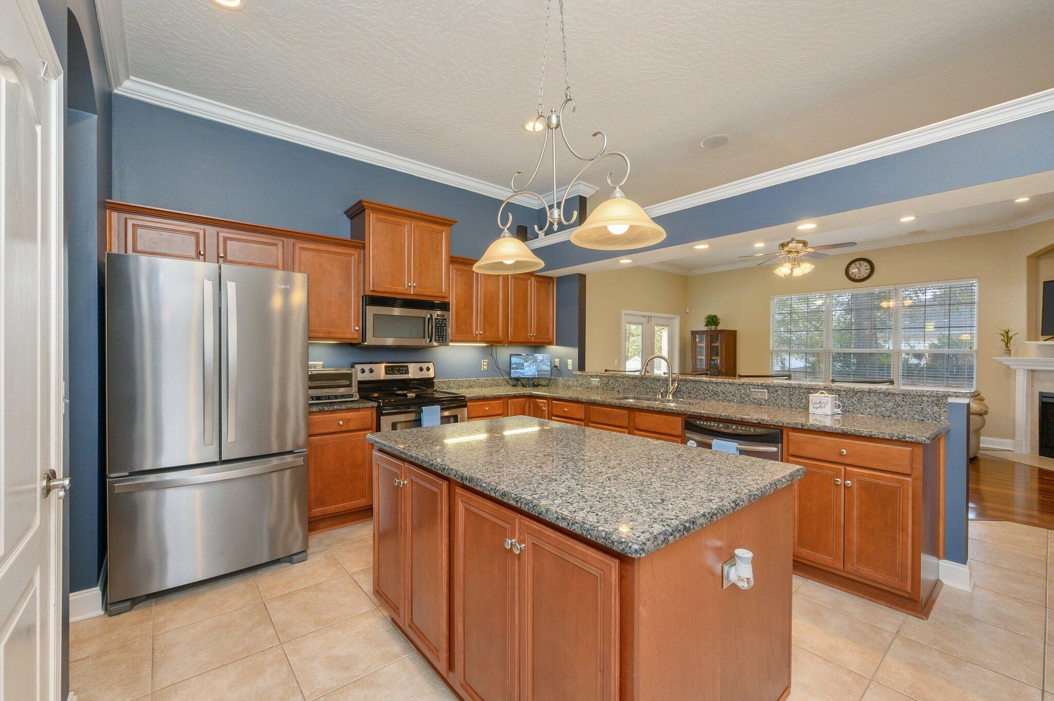 203 Eleases Crossing Crestview, FL 32539 - Photo 13 of 43 a kitchen with stainless steel appliances granite countertop a sink a refrigerator and a view of living room
