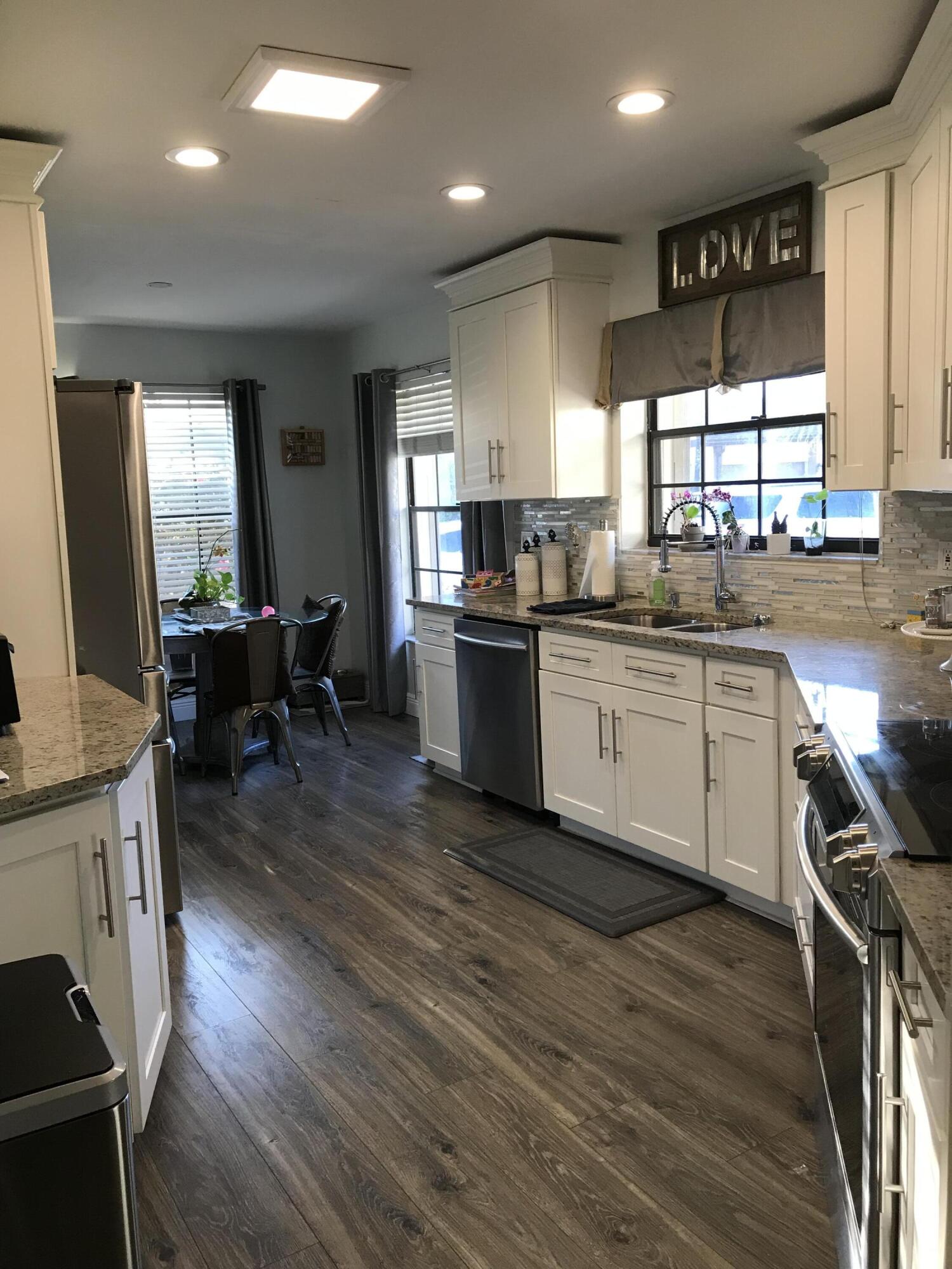 20836 Boca Ridge Drive North Boca Raton, FL 33428 - Photo 3 of 12 a kitchen with stainless steel appliances granite countertop wooden floors and sink