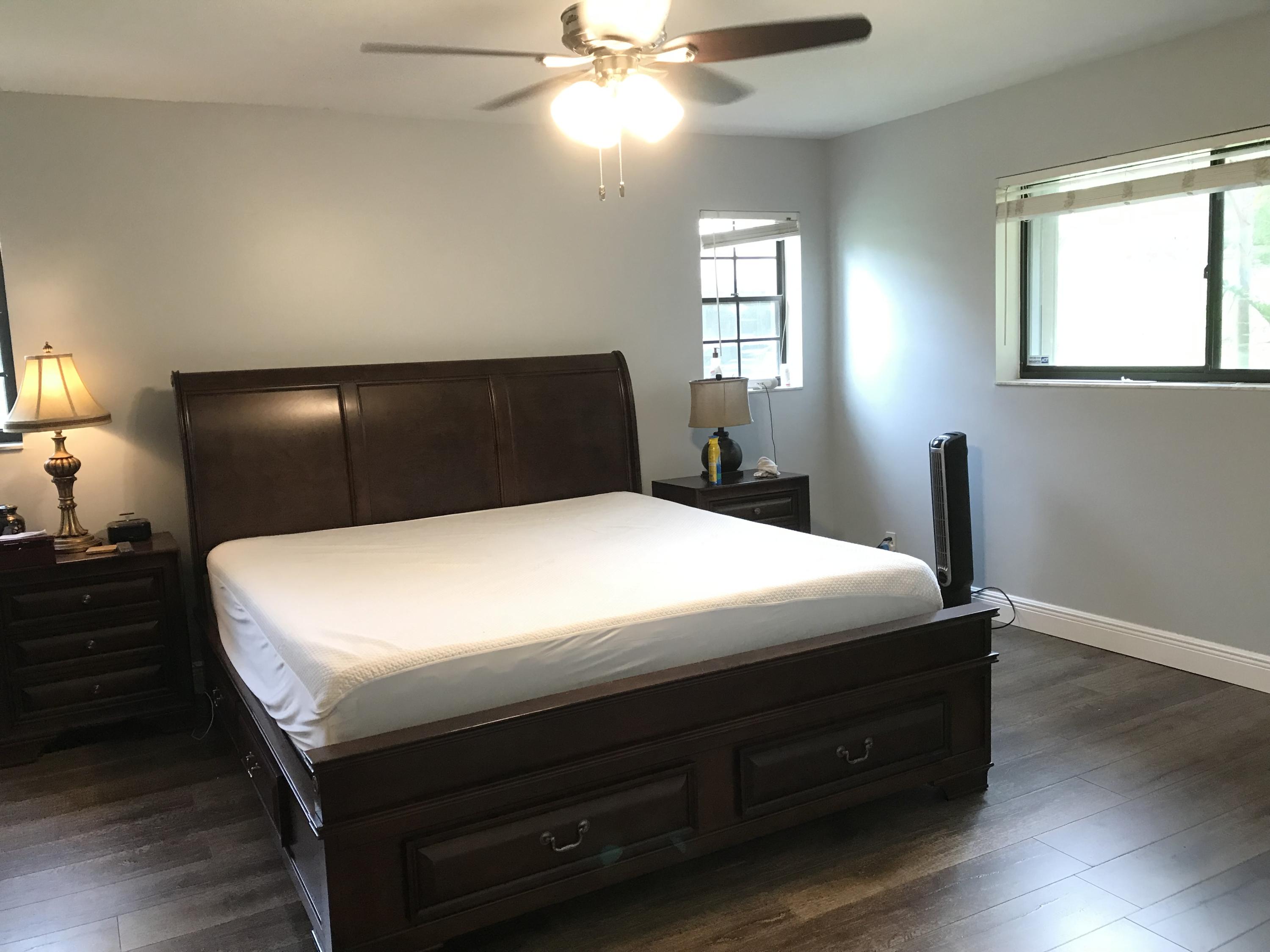 20836 Boca Ridge Drive North Boca Raton, FL 33428 - Photo 4 of 12 a large bed sitting in a bedroom next to a window and a chandelier