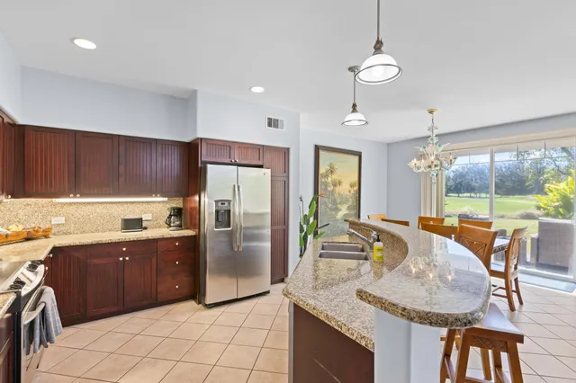 a kitchen with stainless steel appliances granite countertop a sink a stove and a refrigerator