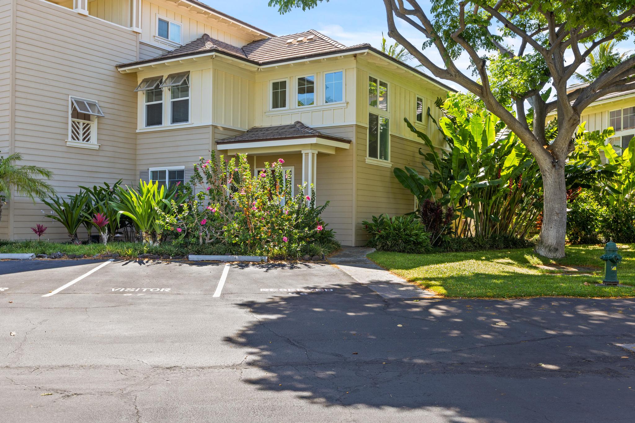 69-200 Pohakulana Place, Unit C4 Waikoloa, HI 96738 - Photo 23 of 30 a front view of a house with a yard and a garage