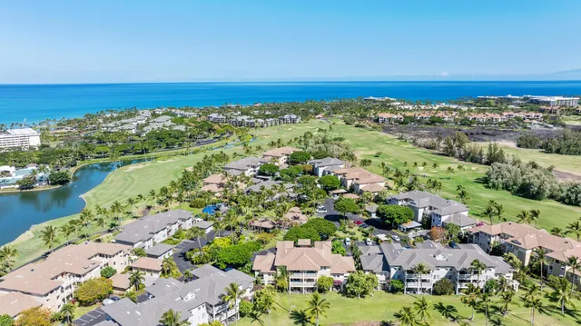 an aerial view of a city with ocean view in back