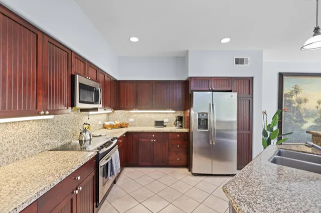 a kitchen with stainless steel appliances granite countertop a refrigerator stove and sink