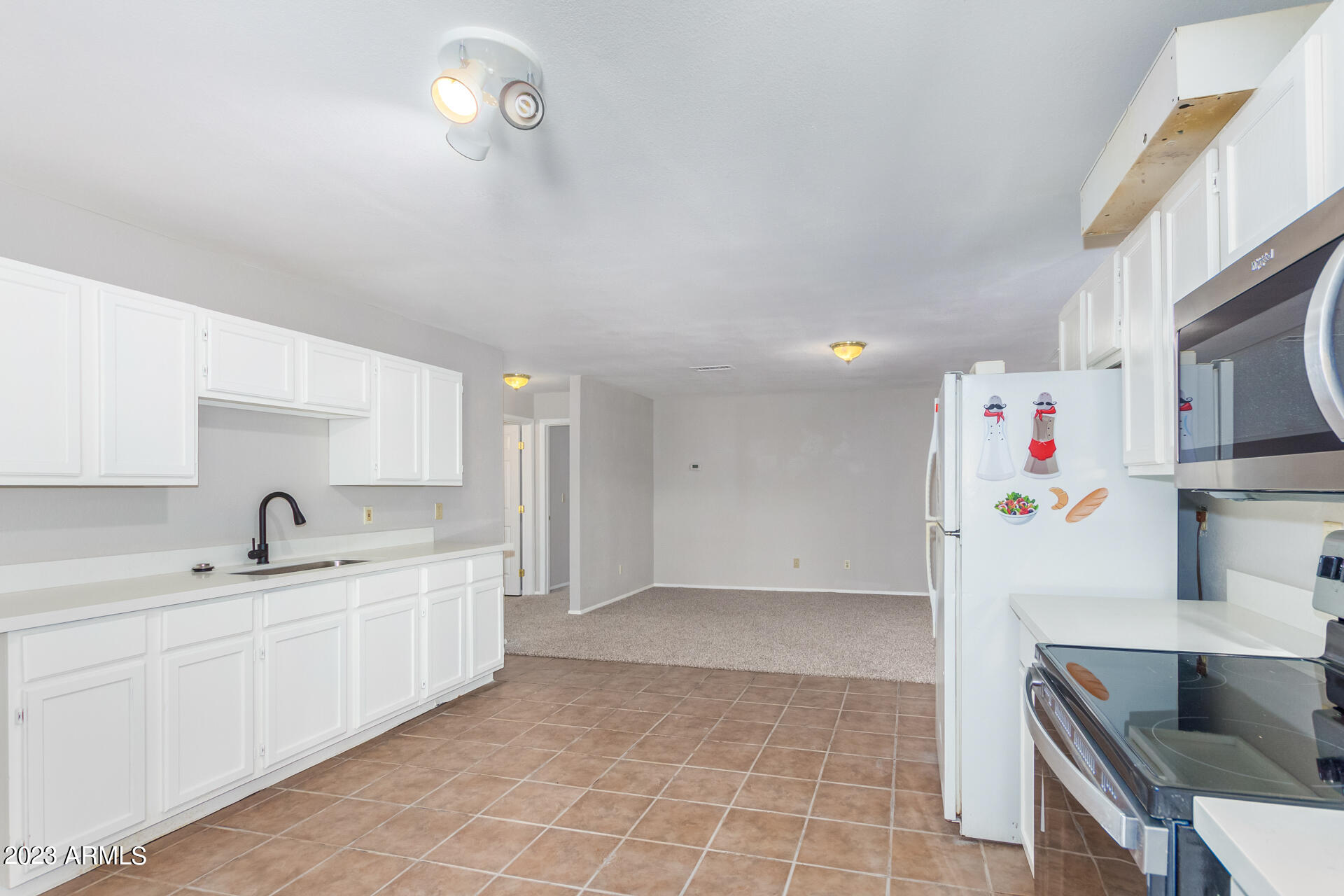 584 Ruben Court Rio Rico, AZ 85648 - Photo 6 of 12 a kitchen with a sink a refrigerator and cabinets