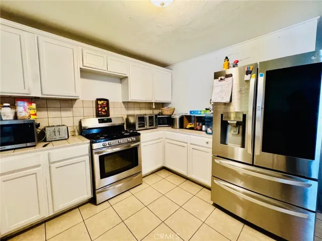 a kitchen with white cabinets and appliances