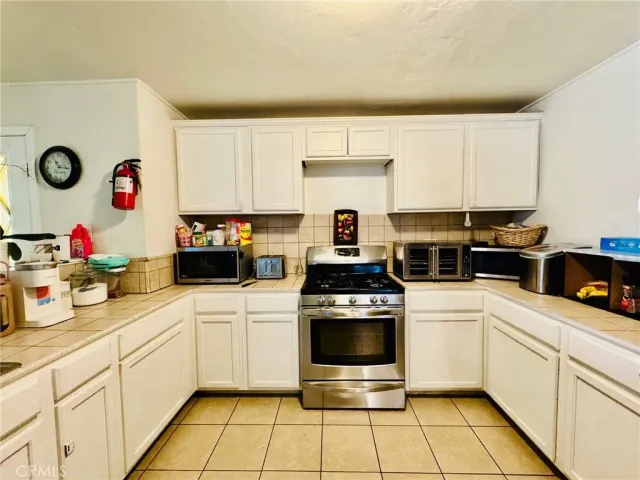 a kitchen with stainless steel appliances kitchen island granite countertop a refrigerator and a stove top oven