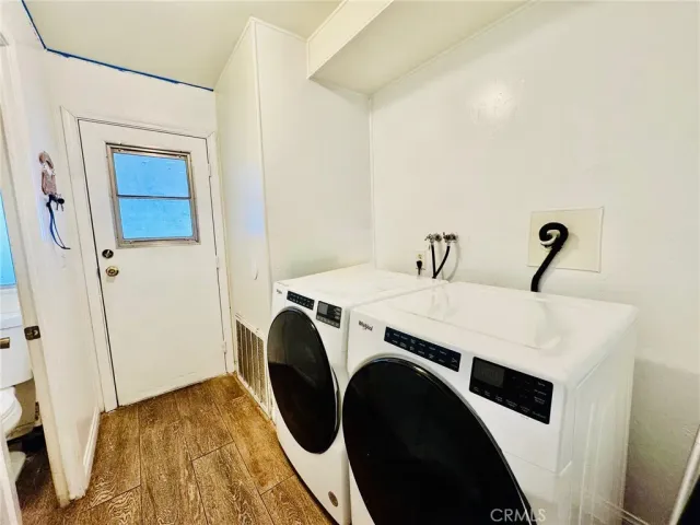 a bedroom with a bed a dresser with wooden floor