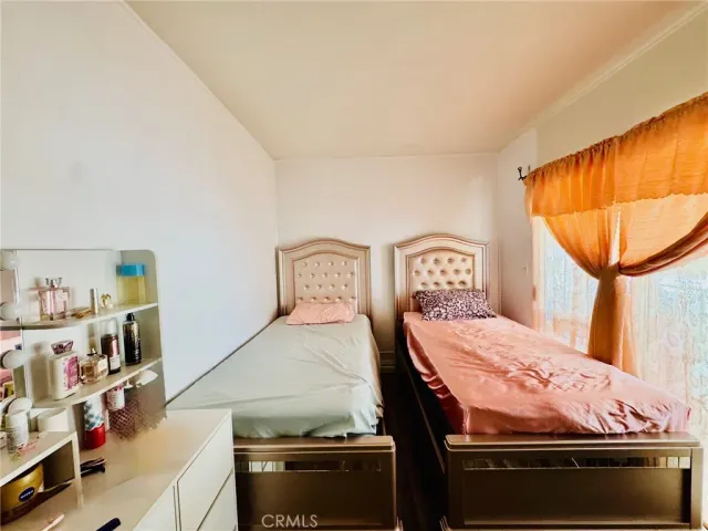 a bedroom with a bed and a flat tv screen on wall