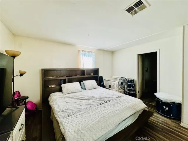 a bedroom with a bed and a flat tv screen on wall