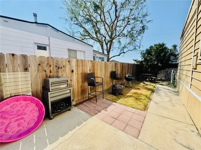 a view of a patio with table and chairs with wooden fence and plants