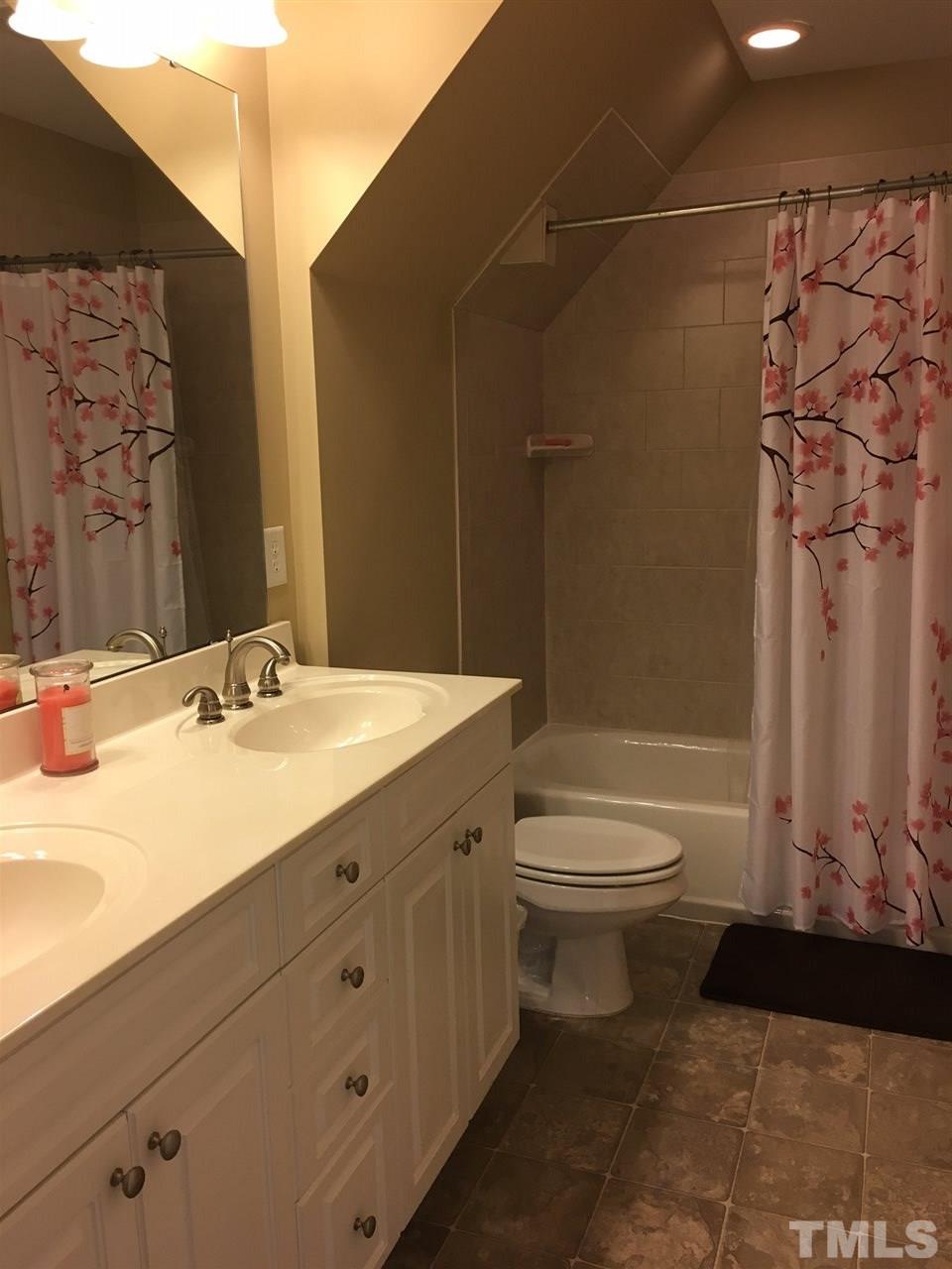 8114 Dreamy Way Raleigh, NC 27613 - Photo 13 of 22 a bathroom with a granite countertop sink toilet a mirror and shower