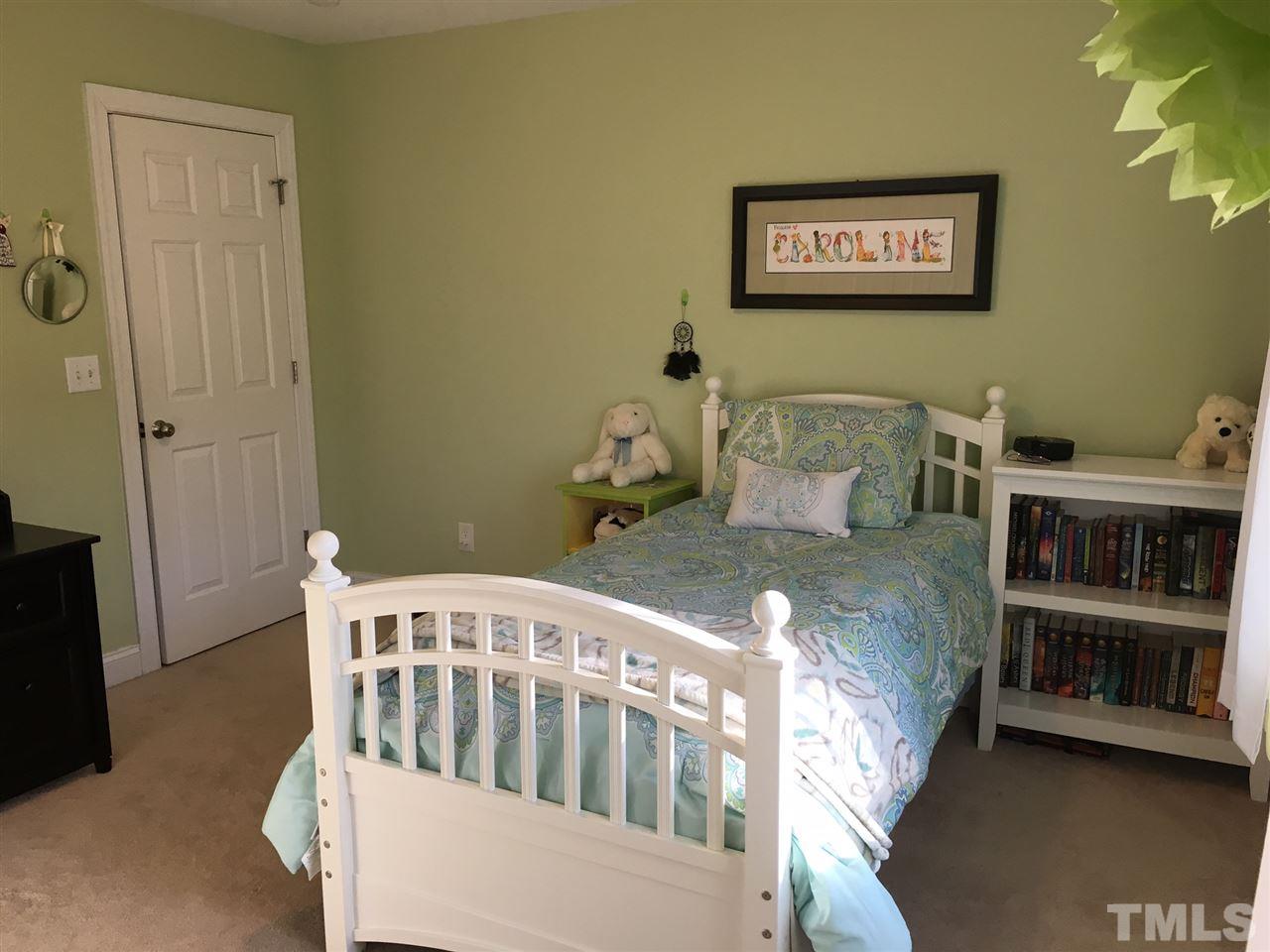 8114 Dreamy Way Raleigh, NC 27613 - Photo 15 of 22 a bedroom with a bed and a book shelf