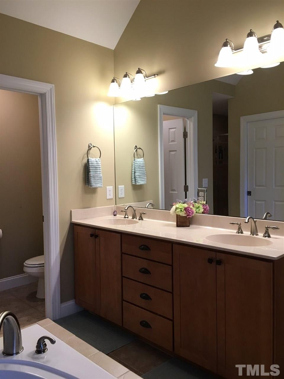 8114 Dreamy Way Raleigh, NC 27613 - Photo 20 of 22 a bathroom with a double vanity sink and a mirror
