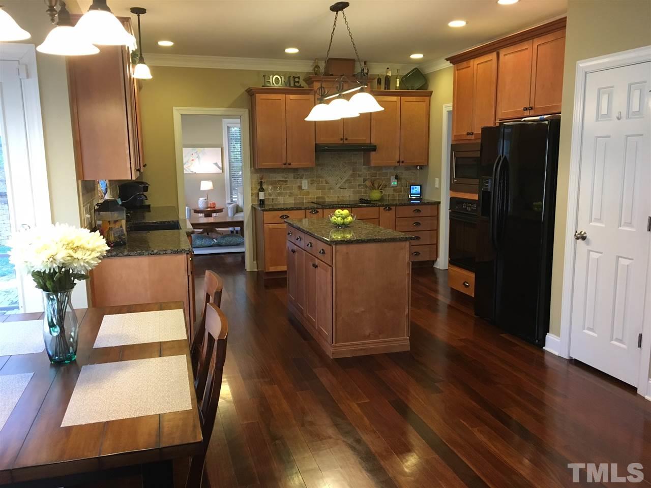 8114 Dreamy Way Raleigh, NC 27613 - Photo 6 of 22 a large kitchen with a table and chairs