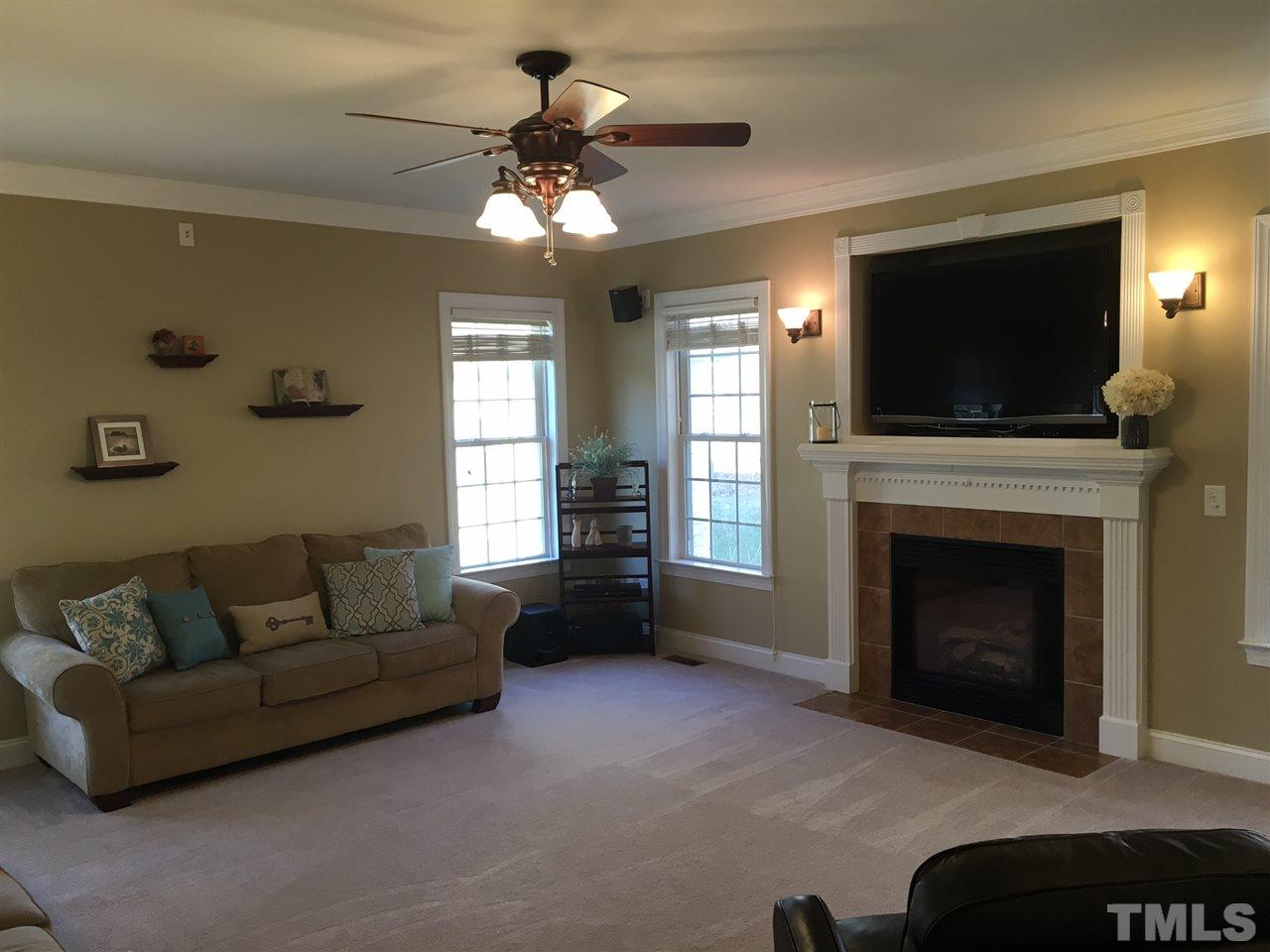 8114 Dreamy Way Raleigh, NC 27613 - Photo 9 of 22 a living room with furniture a flat screen tv and a fireplace