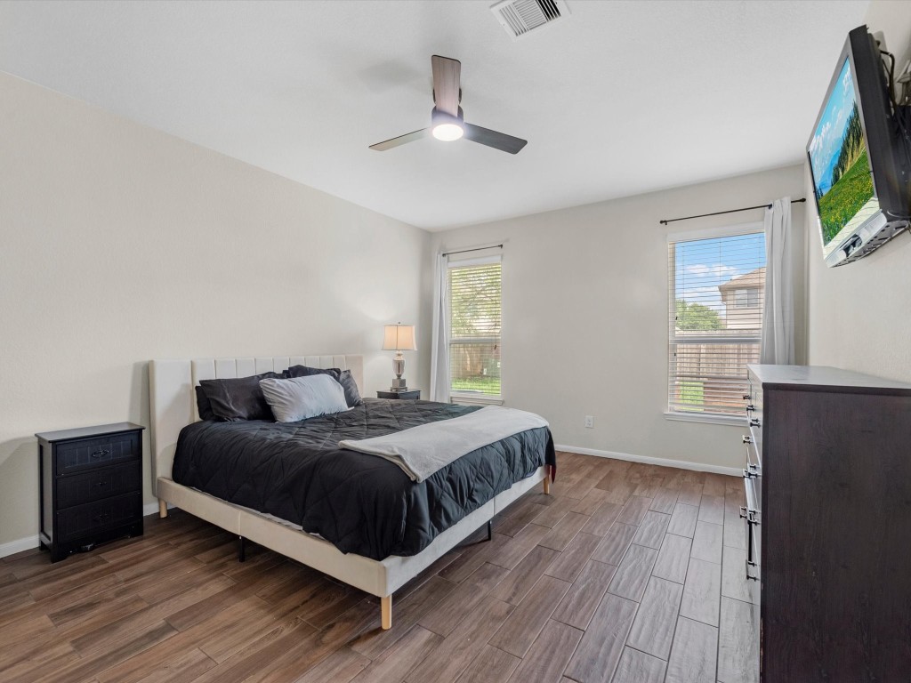 21554 Rainfall Park Drive Spring, TX 77388 - Photo 17 of 36 This spacious primary bedroom features wood-look tile flooring, a neutral color palette, and ample natural light.