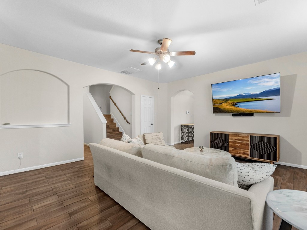 21554 Rainfall Park Drive Spring, TX 77388 - Photo 7 of 36 Spacious living room featuring wood-look tile flooring, neutral walls, and a ceiling fan. Ideal space for relaxation and entertainment.