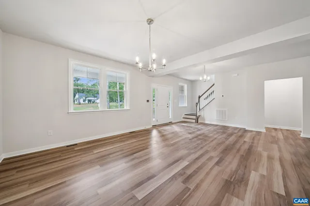 a view of empty room with wooden floor and ceiling fan