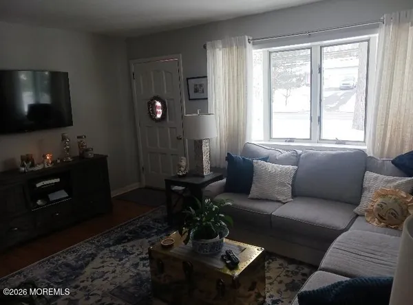 a living room with furniture a flat screen tv and a window