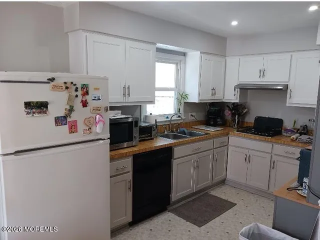 a kitchen with a white cabinets sink and white appliances