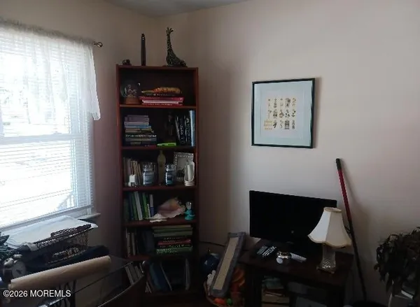 a view of a workspace with furniture and a window