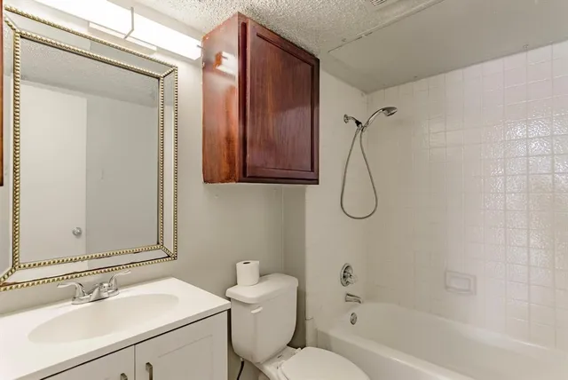 a bathroom with a sink toilet vanity and shower
