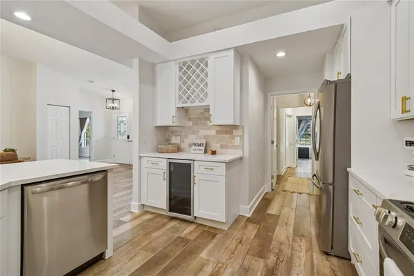 a kitchen with stainless steel appliances a sink a stove a microwave a refrigerator and cabinets