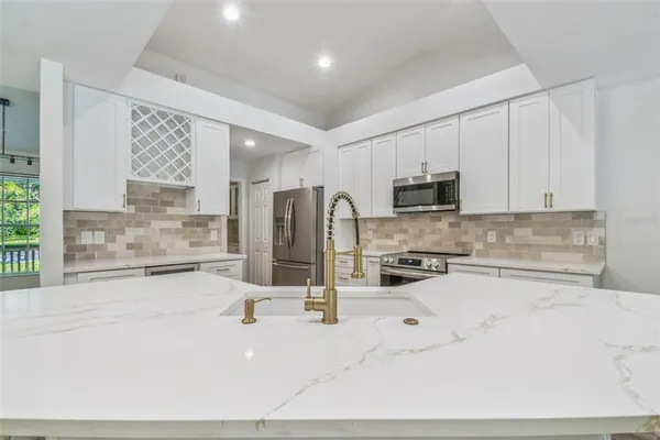 a kitchen with granite countertop white cabinets and stainless steel appliances