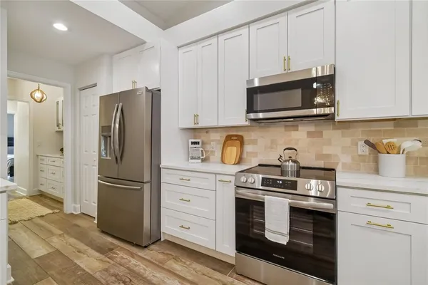 a kitchen with cabinets stainless steel appliances and a counter space