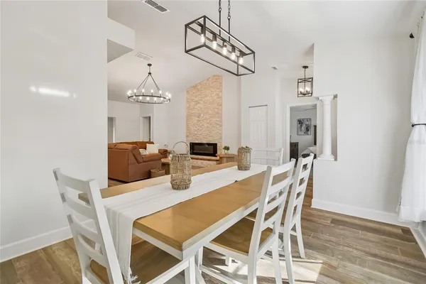 a dining room with furniture a chandelier and wooden floor