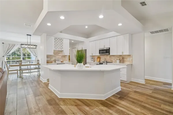 a kitchen with white cabinets and appliances