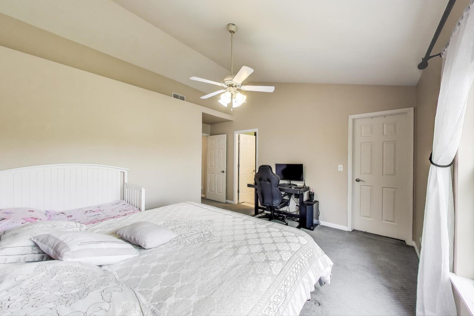 532 Declaration Lane Aurora, IL 60502 - Photo 15 of 34 a bedroom with a bed and a chandelier