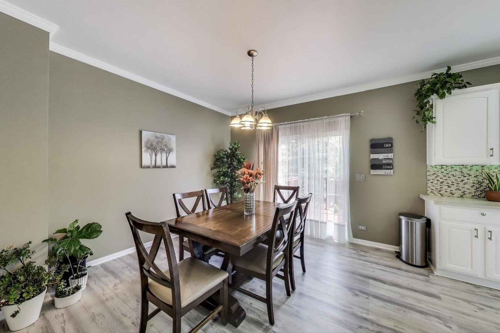 532 Declaration Lane Aurora, IL 60502 - Photo 6 of 34 a dining room with furniture potted plants and wooden floor