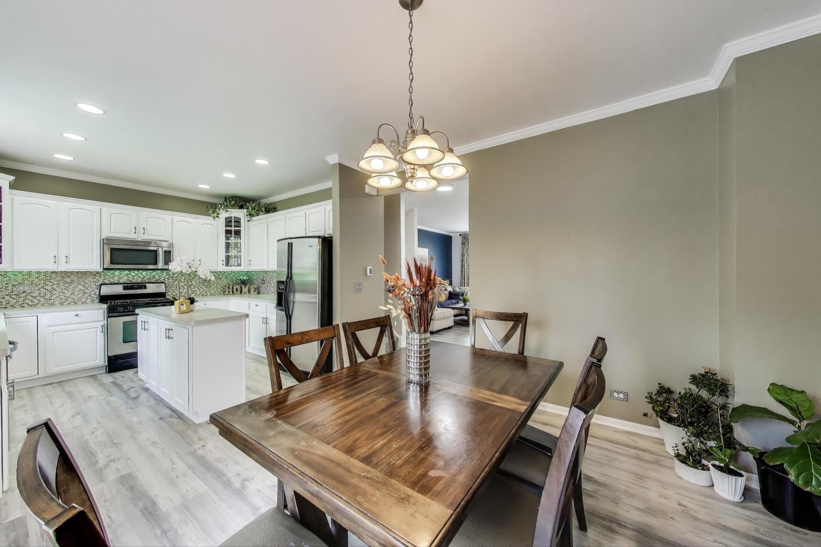 532 Declaration Lane Aurora, IL 60502 - Photo 8 of 34 a kitchen with a dining table chairs stainless steel appliances and cabinets