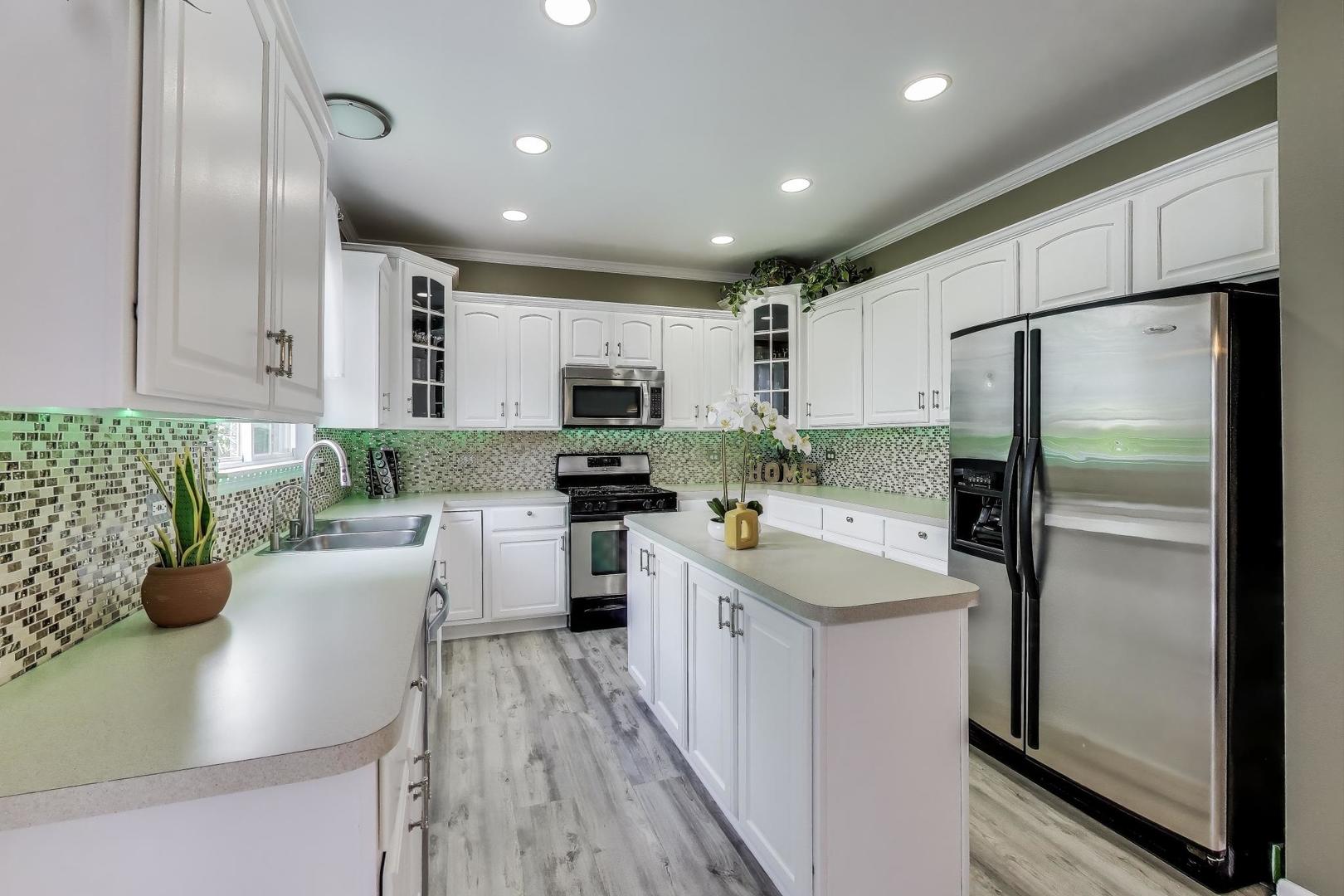 532 Declaration Lane Aurora, IL 60502 - Photo 9 of 34 a kitchen with white cabinets and stainless steel appliances