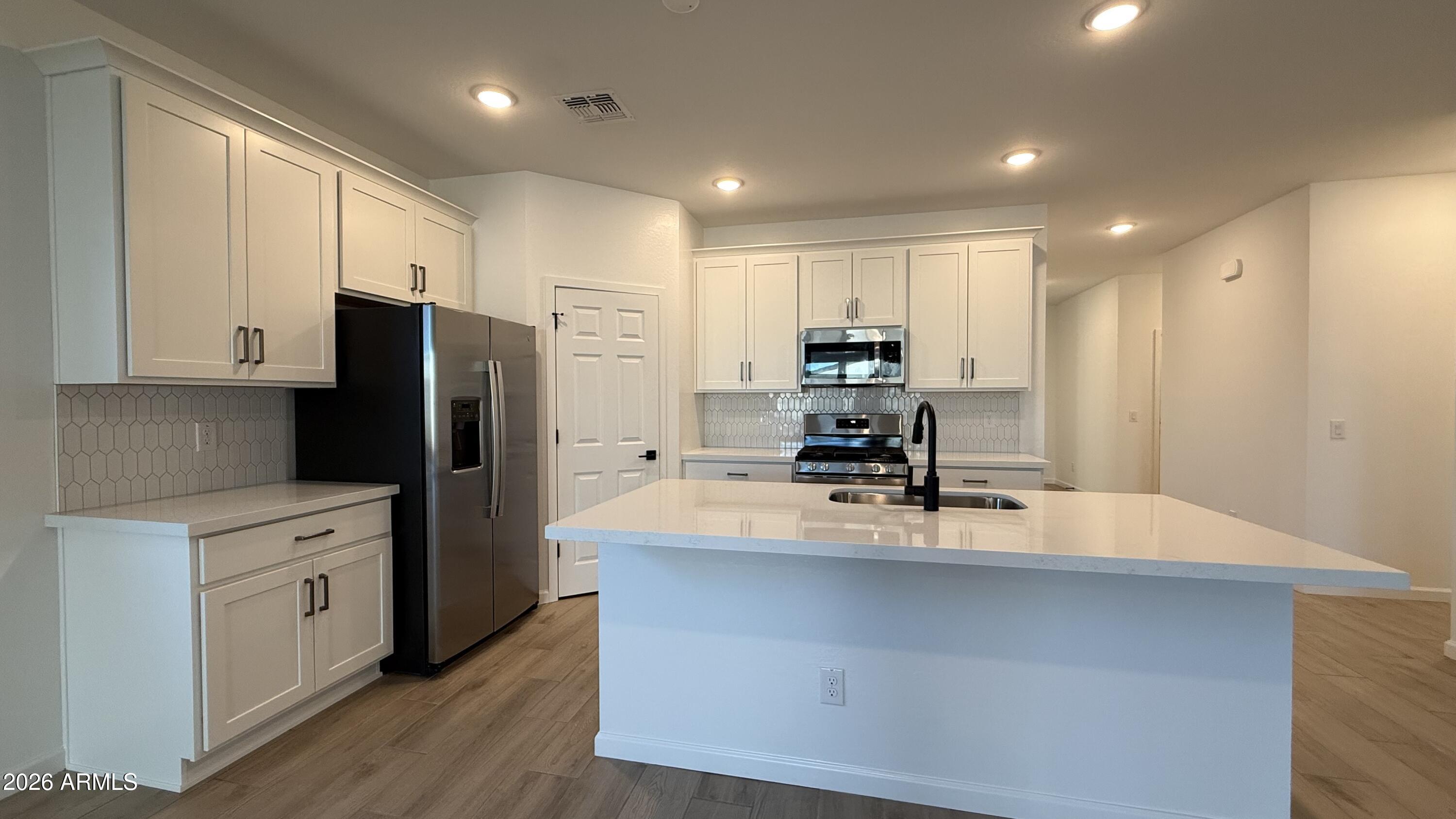 46818 West Old Timer Road Maricopa, AZ 85139 - Photo 13 of 34 a kitchen with kitchen island a counter top space cabinets and stainless steel appliances