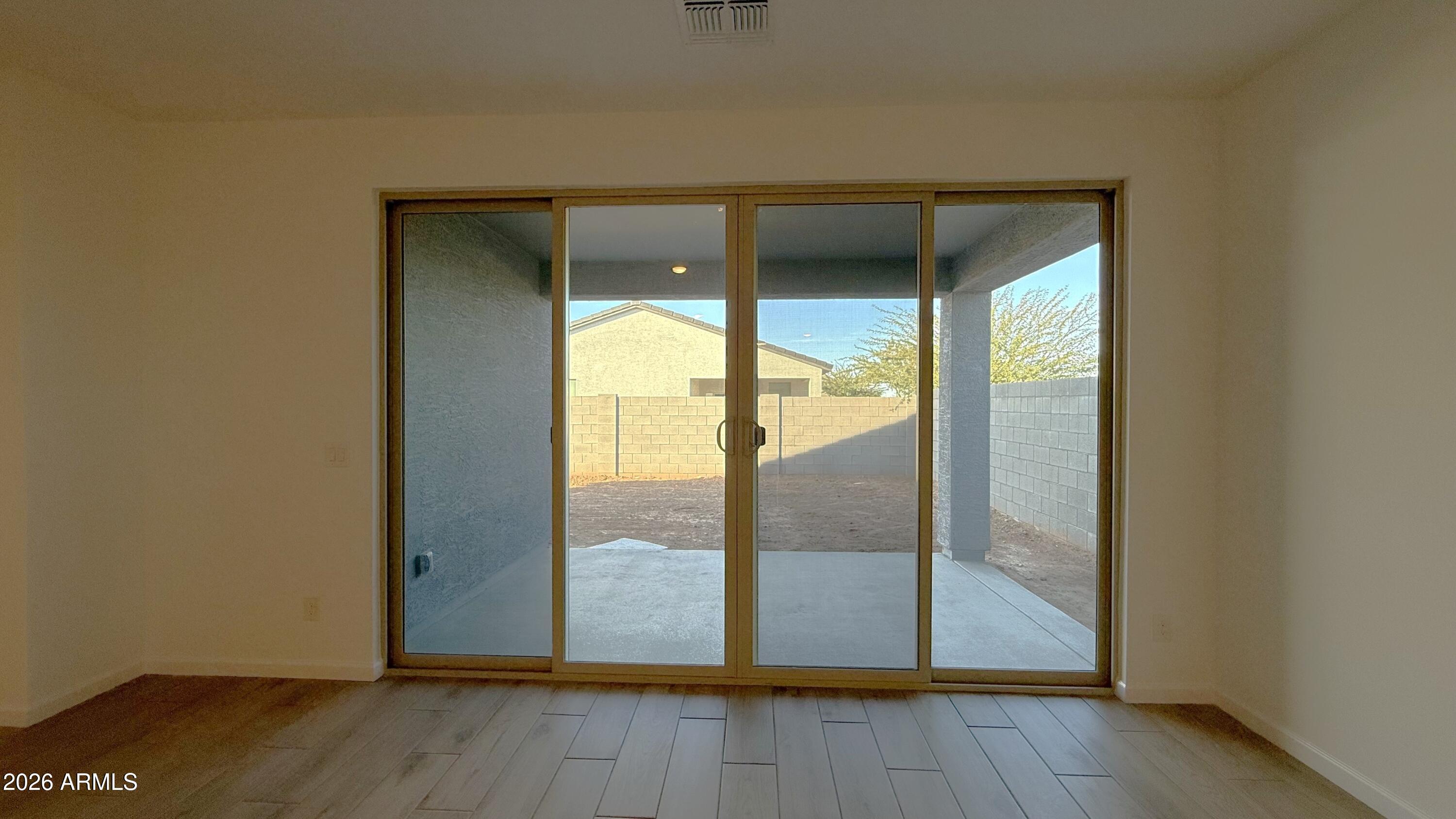 46818 West Old Timer Road Maricopa, AZ 85139 - Photo 14 of 34 an empty room with wooden floor and glass door