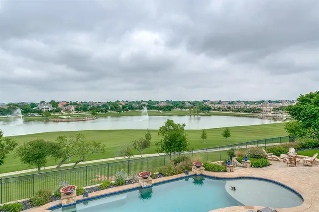 a view of a lake with a yard from a balcony