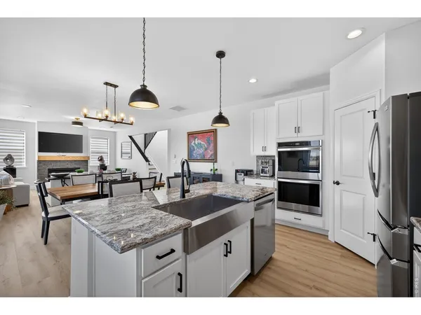 a kitchen with kitchen island granite countertop a sink appliances and cabinets