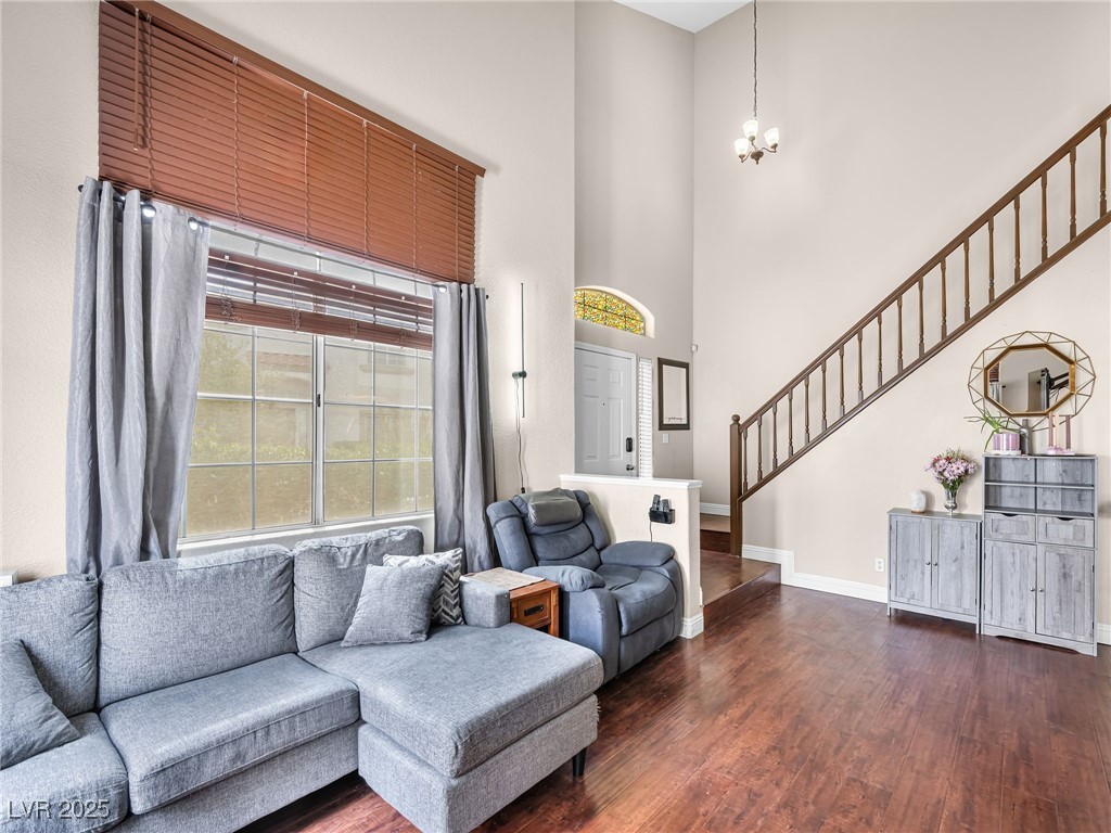 353 Seine Way, Unit N Henderson, NV 89014 - Photo 9 of 36 Living room with baseboards, dark wood finished floors, stairway, and a towering ceiling.