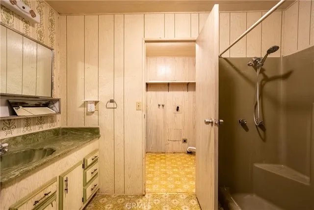 a bathroom with a granite countertop sink and shower
