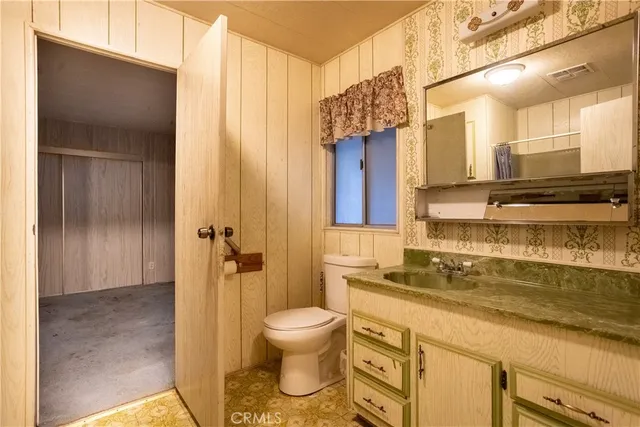 a bathroom with a granite countertop sink a toilet and shower